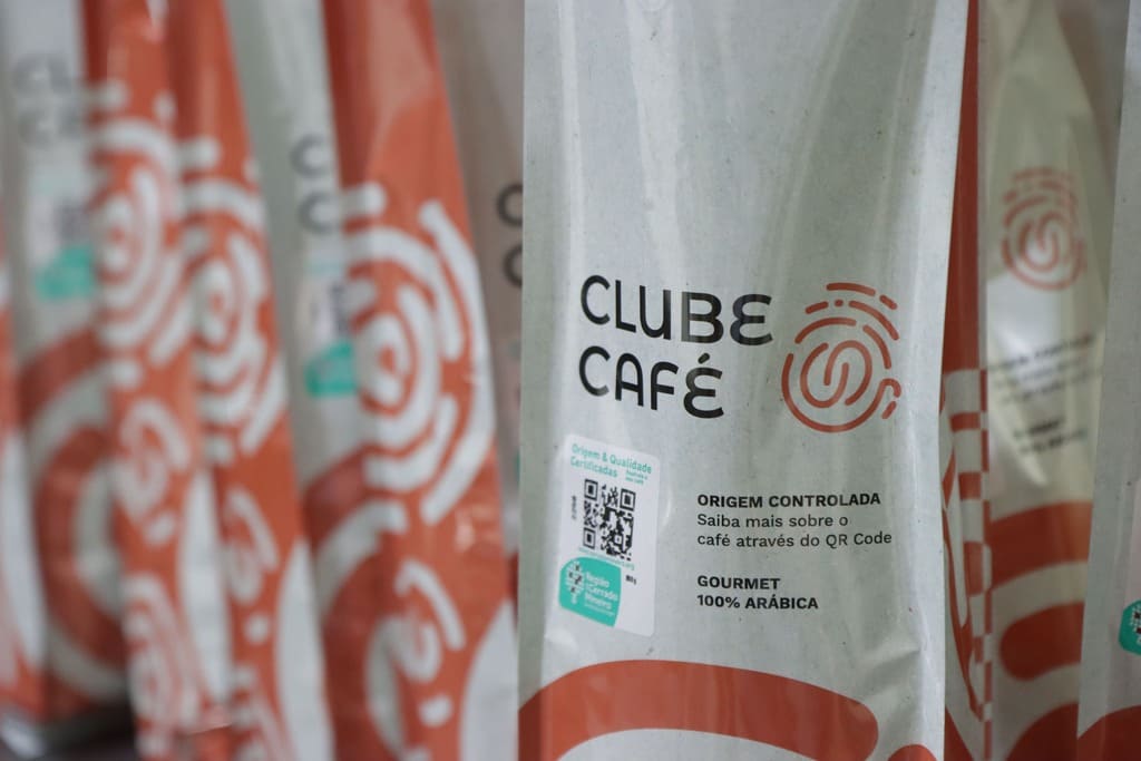 Várias embalagens de café Clube Café enfileiradas, destacando o design moderno e o selo de origem controlada.